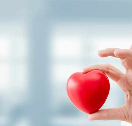 Photo montrant une main qui tient une pomme rouge